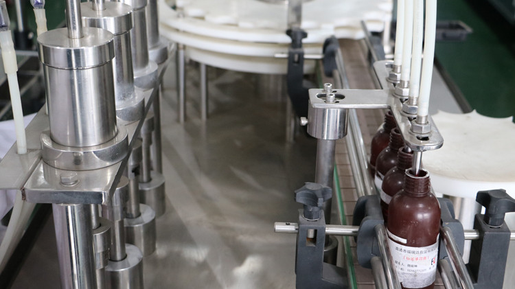 Riempitrice per bottiglie rotonde da 500 ml con tappo di chiusura e ruota a stella in funzione